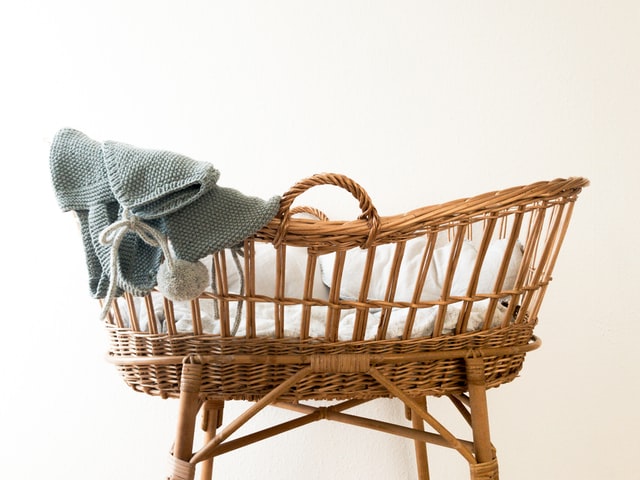 gray textile hanging on brown wicker bassinet